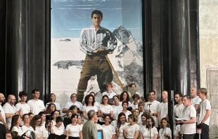 A choir poses before an image of Pier Giorgio Frassati during a celebration of the centenary of his death, Turin, Italy, Friday, July 4, 2025. Credit: Courtney Mares/CNA