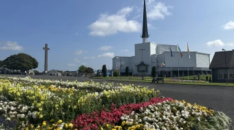Flowers stand before Knock Shrine in Knock, Ireland, Friday, Aug. 15, 2025