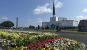 Flowers stand before Knock Shrine in Knock, Ireland, Friday, Aug. 15, 2025