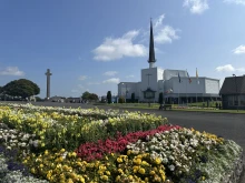 Flowers stand before Knock Shrine in Knock, Ireland, Friday, Aug. 15, 2025