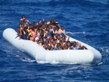 Migrants aboard an inflatable vessel in the Mediterranean Sea approach the guided-missile destroyer USS Carney in 2013. Carney provided food and water to the migrants aboard the vessel before coordinating with a nearby merchant vessel to take them to safety.