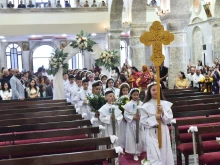 Children process into the St. Mary al-Tahir Church, also known as the Church of the Immaculate Conception, in Baghdad, for their first Communion.
