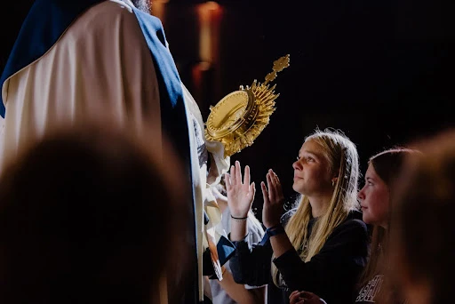 A high school camper venerates the Eucharist at Wednesday night adoration in 2024 at the Damascus main campus, Centerburg, Ohio.?w=200&h=150