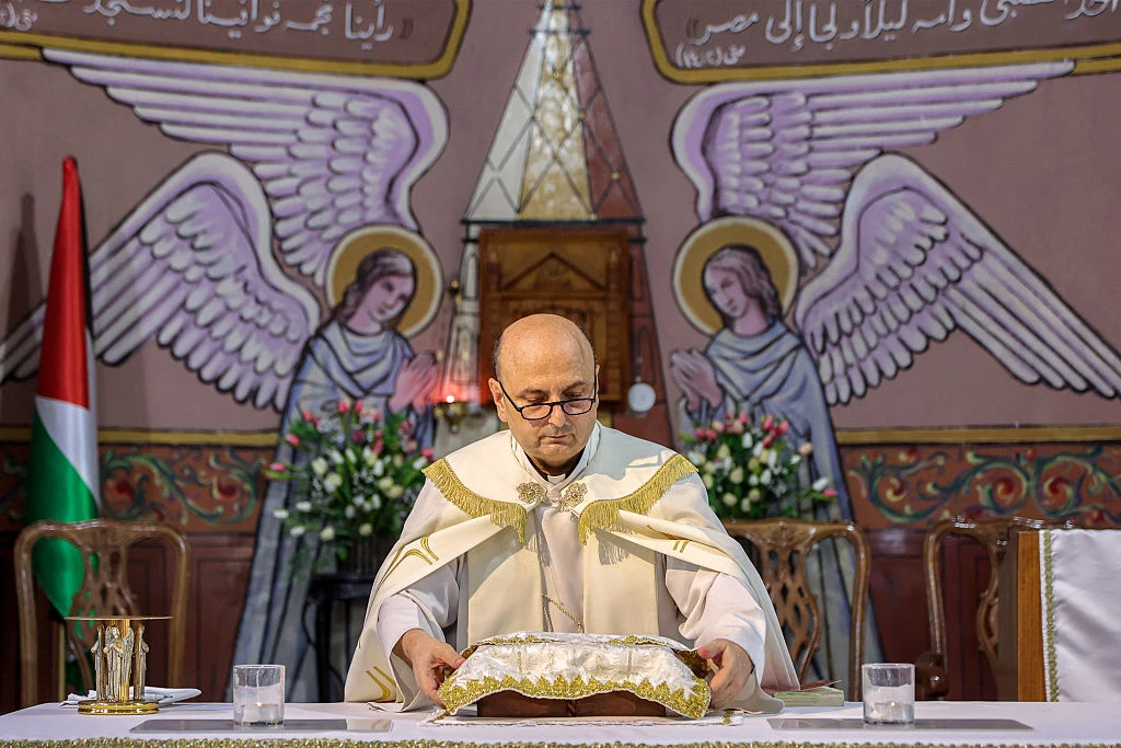 Father Gabriel Romanelli, parish priest at the Roman Catholic Church of the Holy Family who was wounded in a recent strike on the church, stands before the altar during a Sunday morning Mass held by the Latin patriarch of Jerusalem at the church in Gaza City on July 20, 2025.?w=200&h=150