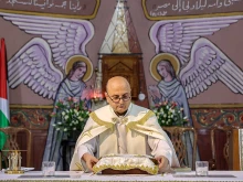 Father Gabriel Romanelli, parish priest at the Roman Catholic Church of the Holy Family who was wounded in a recent strike on the church, stands before the altar during a Sunday morning Mass held by the Latin patriarch of Jerusalem at the church in Gaza City on July 20, 2025.
