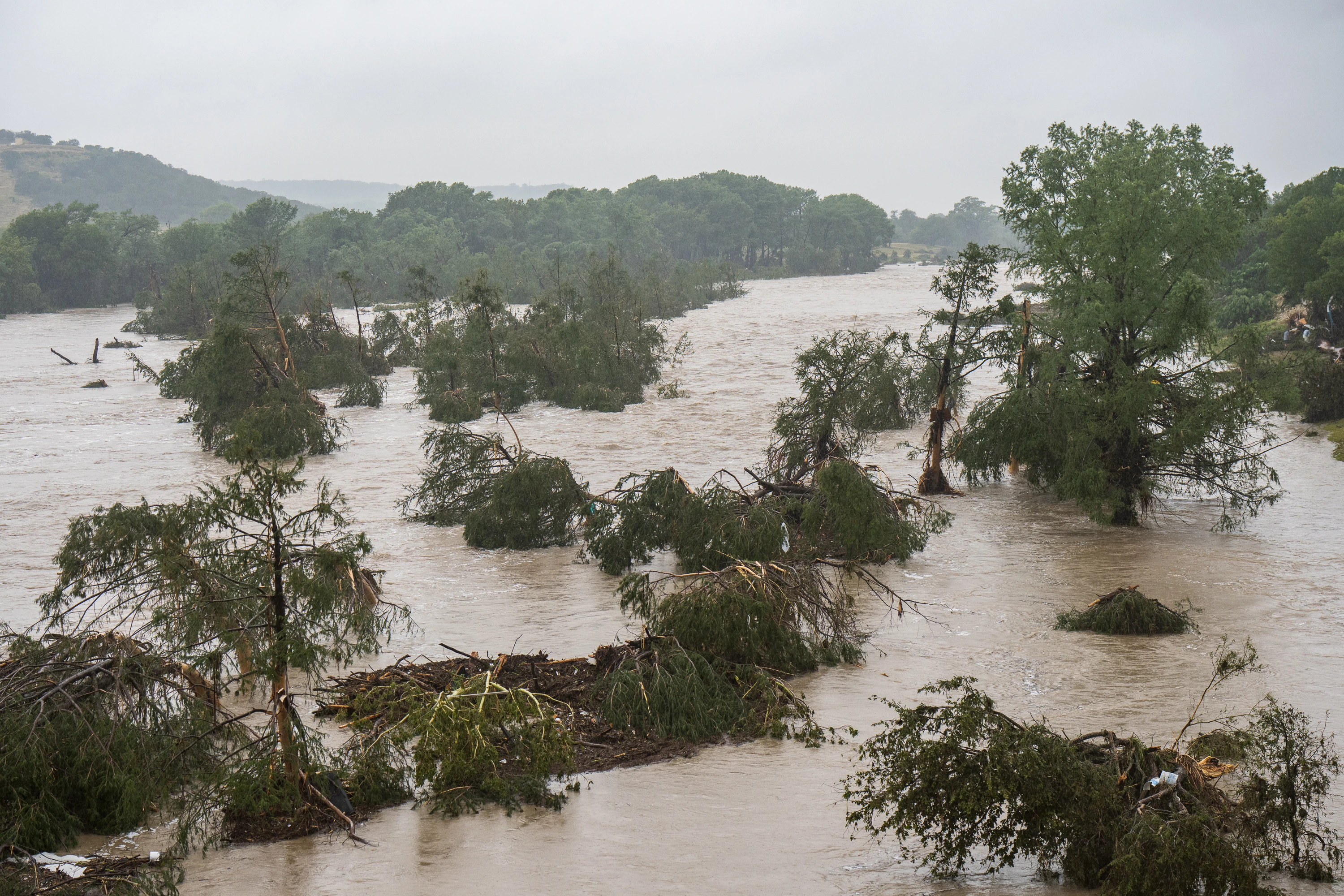 Trees emerge from flood waters along the Guadalupe River on July 4, 2025, in Kerrville, Texas. Heavy rainfall caused flooding along the Guadalupe River in central Texas with multiple fatalities reported.?w=200&h=150