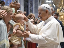 Pope Leo XIV blesses a baby during his Wednesday general audience in St. Peter’s Basilica on Aug. 13, 2025, at the Vatican.