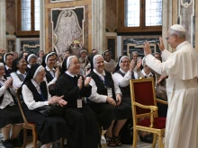 Pope Leo XIV smiles and waves to a group of nuns during an audience with women religious on June 30, 2025, at the Vatican.