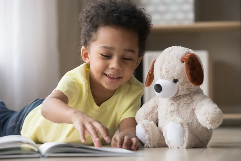 Boy reading toy dog a book