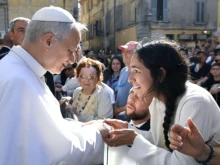 Pope Leo XIV greets a young woman along the streets of Albano, Italy, before offering Mass in the Cathedral Basilica of St. Pancras near Castel Gandolfo on July 20, 2025.